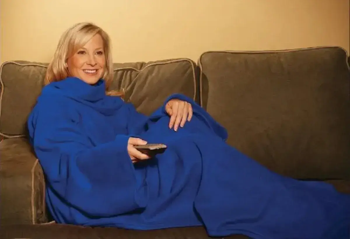 People laughing together in sleeved blankets