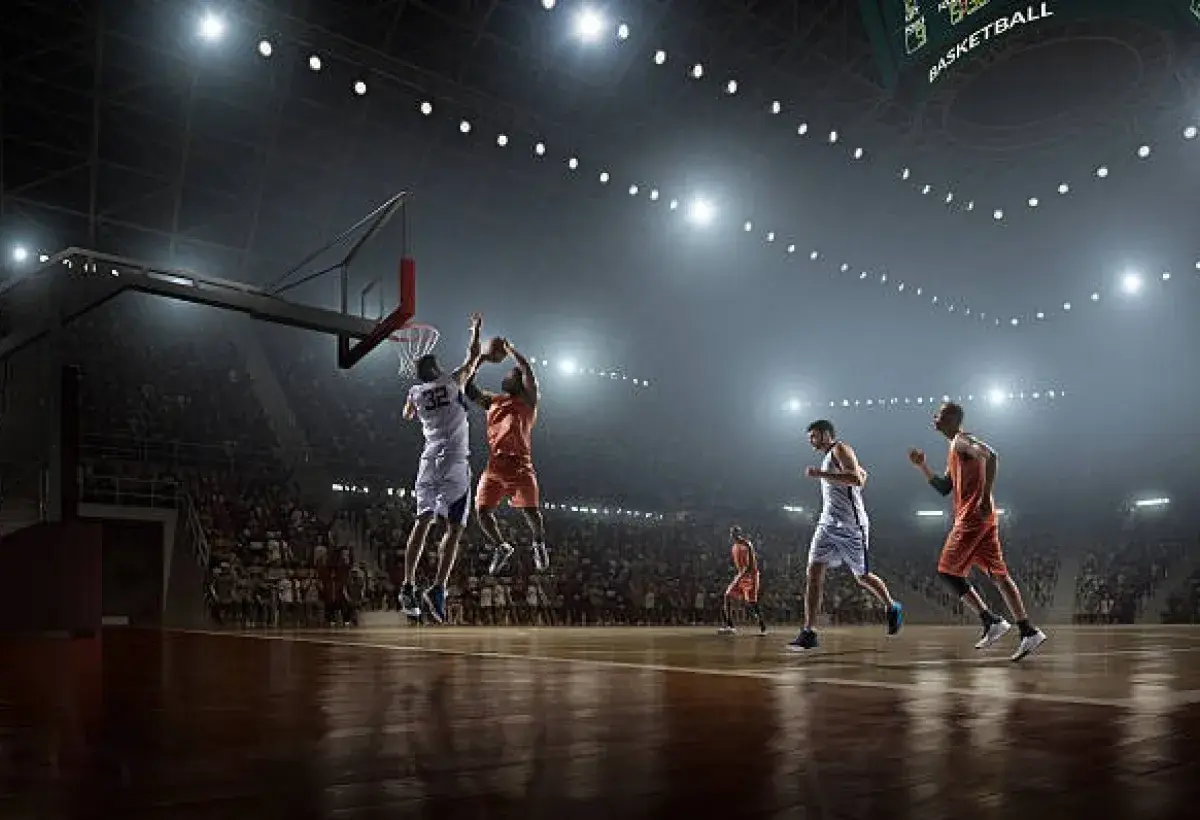 Basketball player executing slam dunk during sold out NBA game