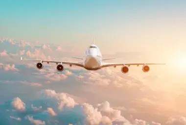 Commercial jet flying at sunset above the clouds