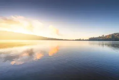 Sunrise over a calm lake representing inner peace and reflection