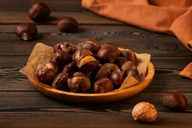 Bowl of Freshly Roasted Chestnuts on Rustic Wooden Table
