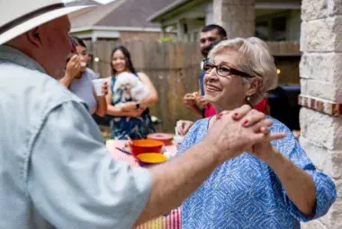 Elderly couple embraced by family and community symbolizing respect and empowerment
